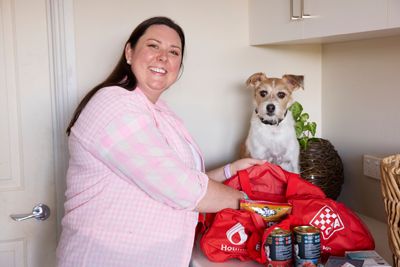 Dog watching as owner fills bag with dog food
