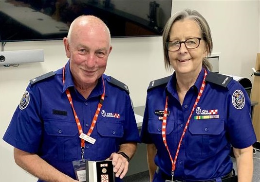 Captain Deb Luke AFSM presents 25-year service medal to John Farmelo