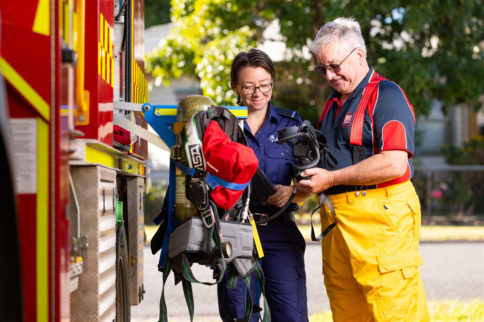 Two members inspect equipment on the truck