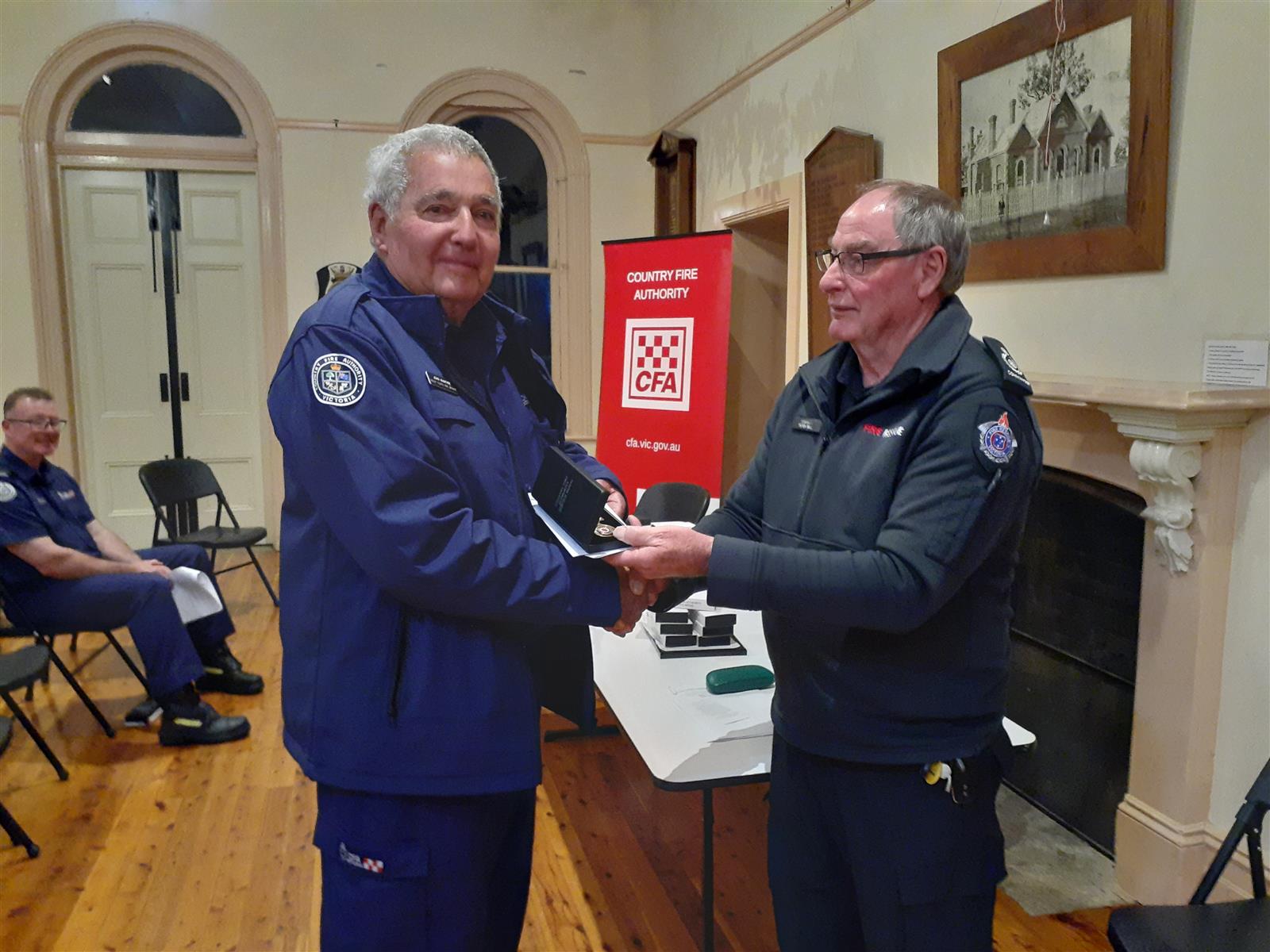 Firefighter John McIntyre receives his 60-year service medal from D23 Commander Peter Bell Firefighter John McIntyre receives his 60-year service medal from D23 Commander Peter Bell
