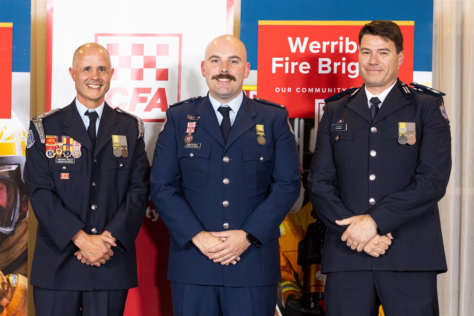 Lieutenant Rohan Rizzoli receives his 15 Year Service Medal from Captain Michael Wells and Commander Joe Gomez
