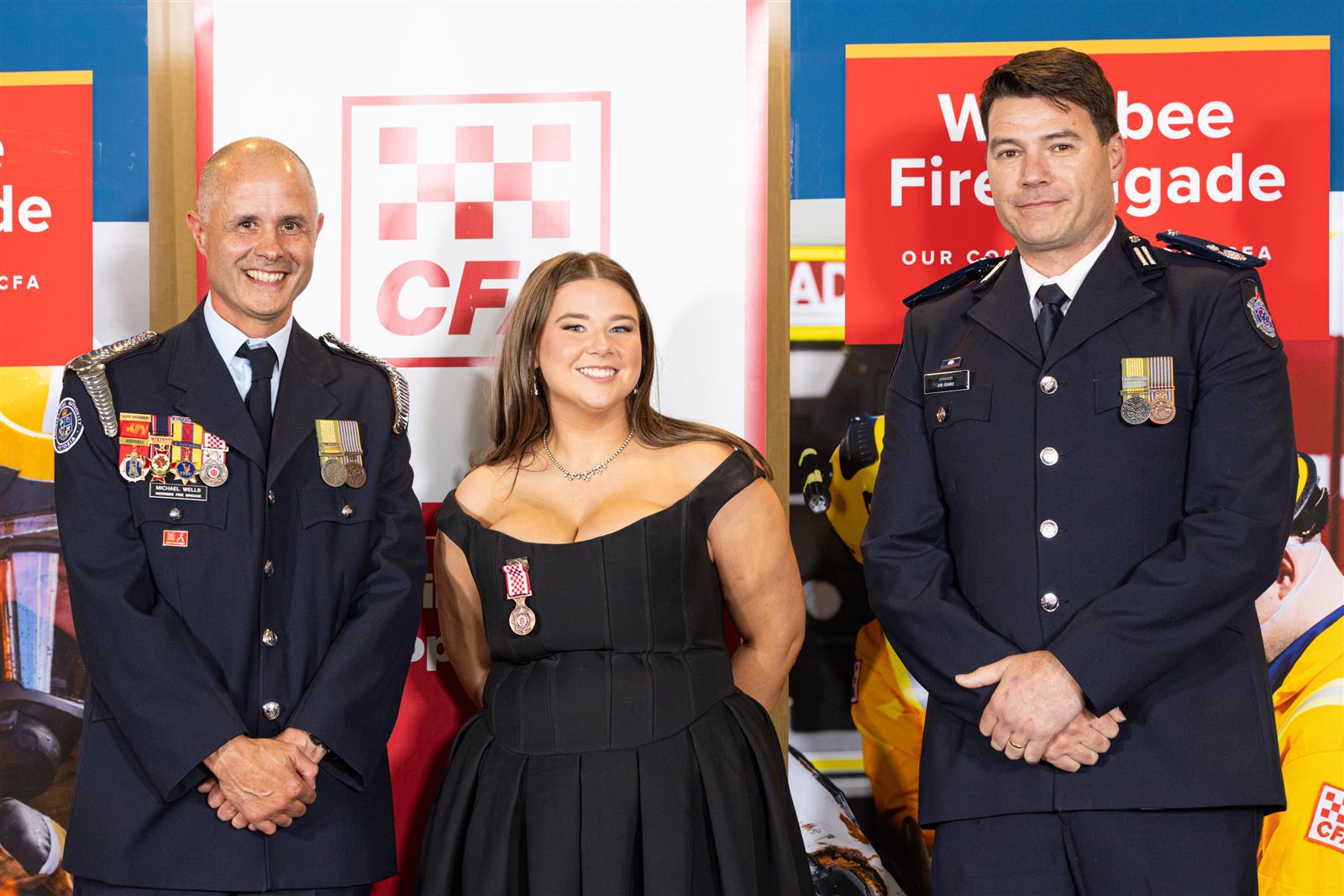 Firefighter Alannah Inglis receives her 10 Year Service Medal from Captain Michael Wells and Commander Joe Gomez